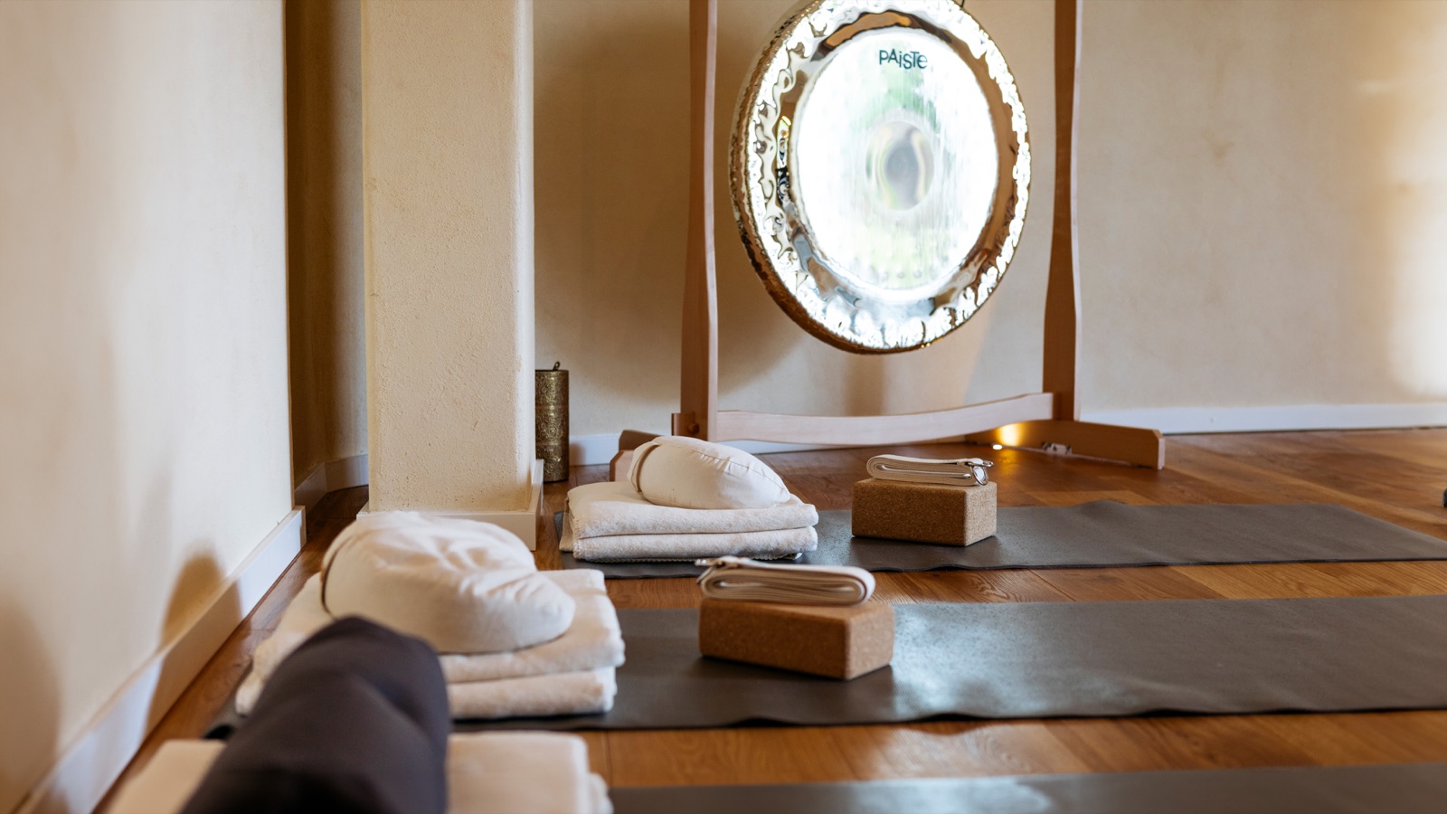 Glänzender Gong über Meditationskissen und Matten im Nivas Bielefeld