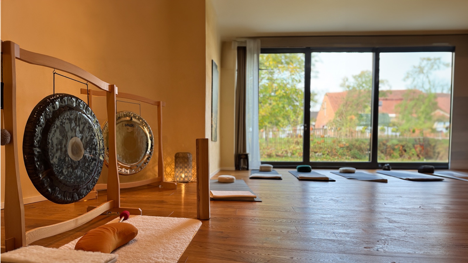 Heller Klangraum im Nivas Bielefeld mit ausgelegten Matten und Gongs vor dem Fenster
